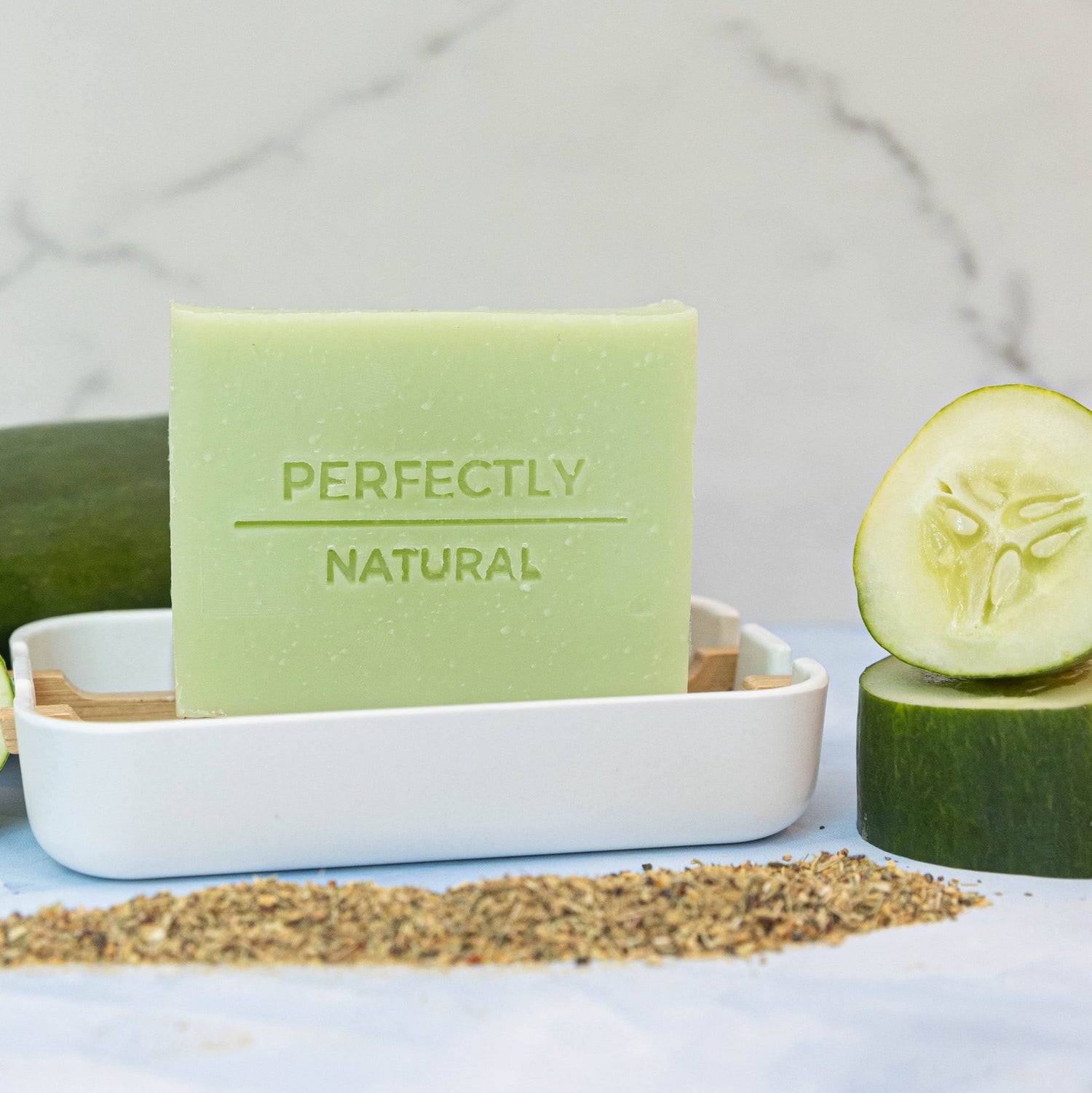Light Green Soap Bar on White Soap dish surrounded by cucumners and green tea