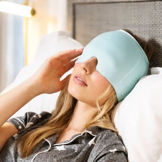 Woman wearing a light blue sleep mask in bed