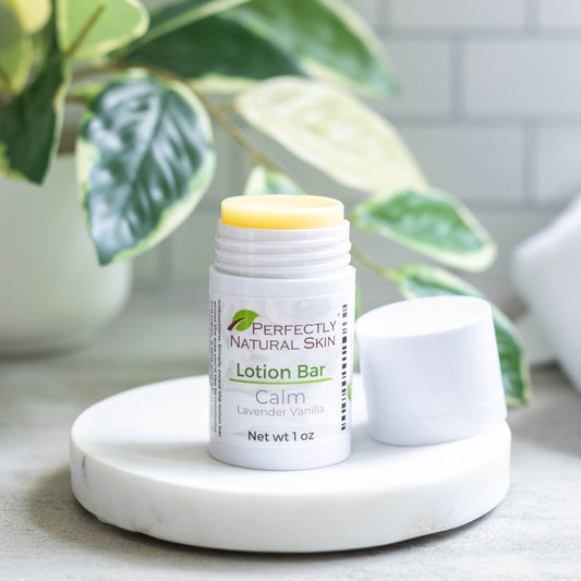 Lotion bar on a marble coaster with a plant in the background